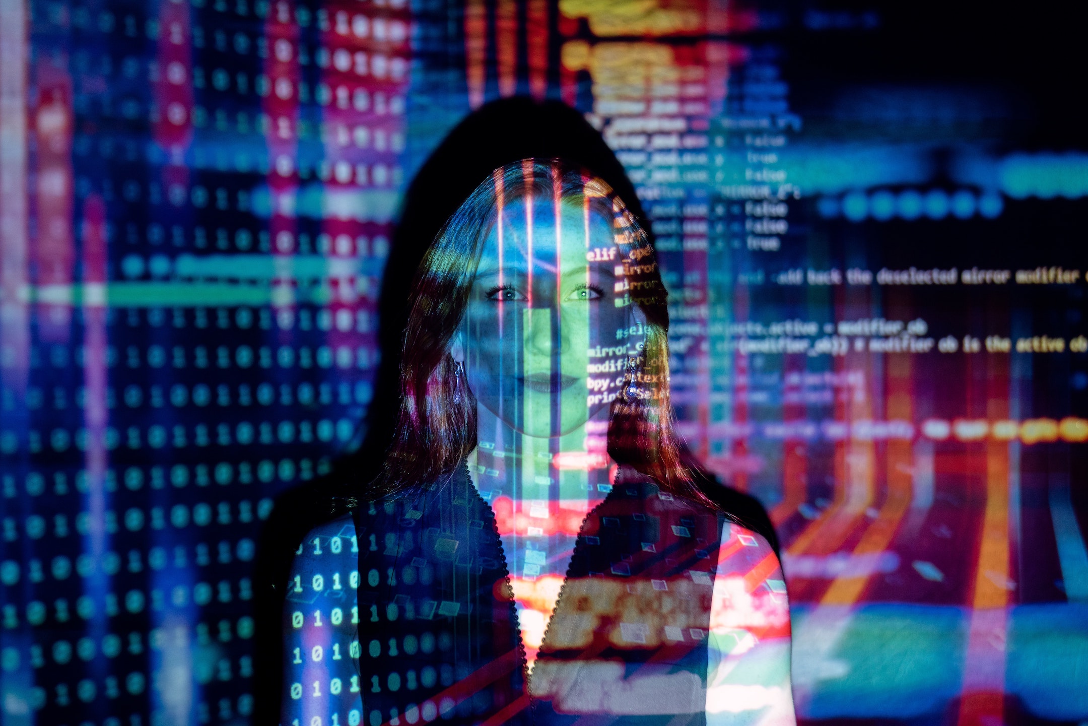 young woman standing in front of a computer screen of data