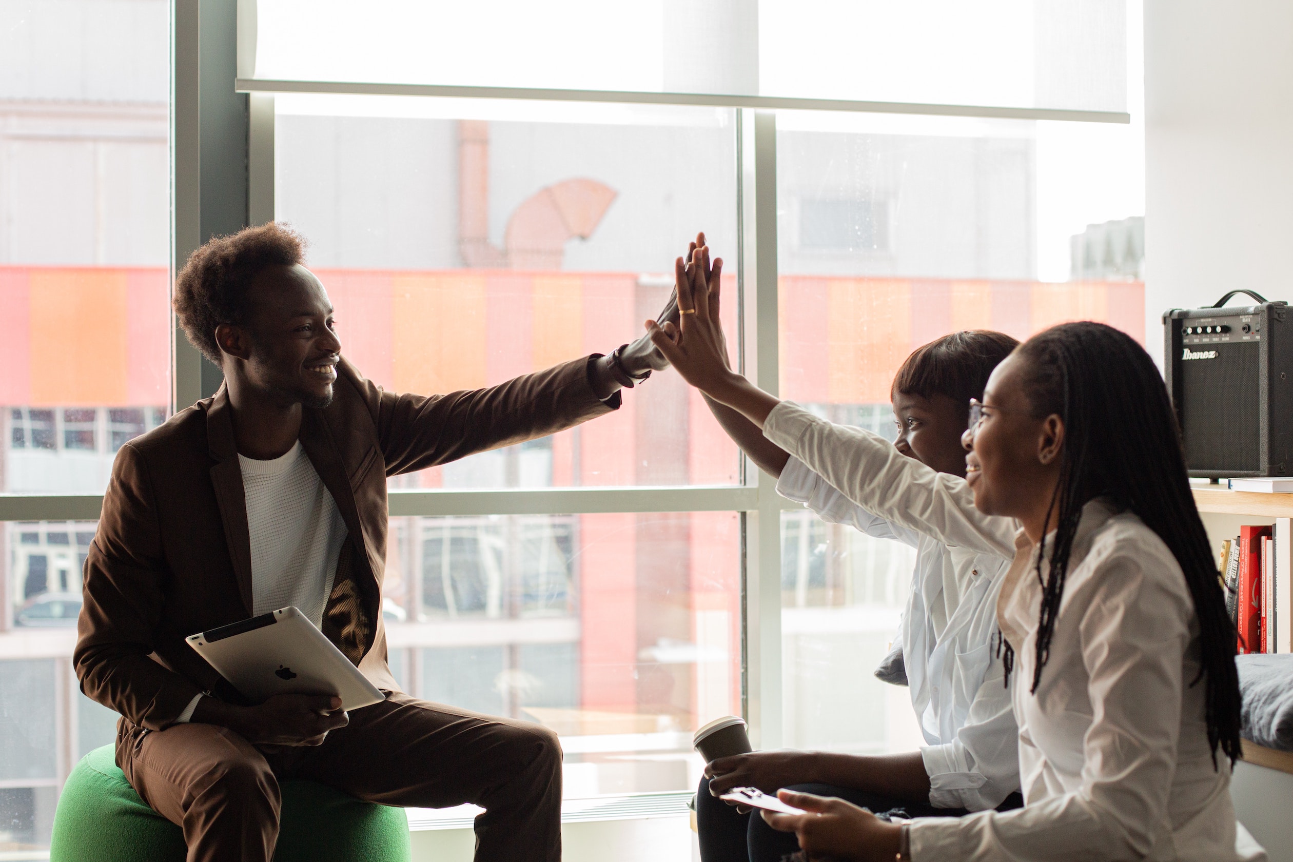 three black business professionals celebrating success